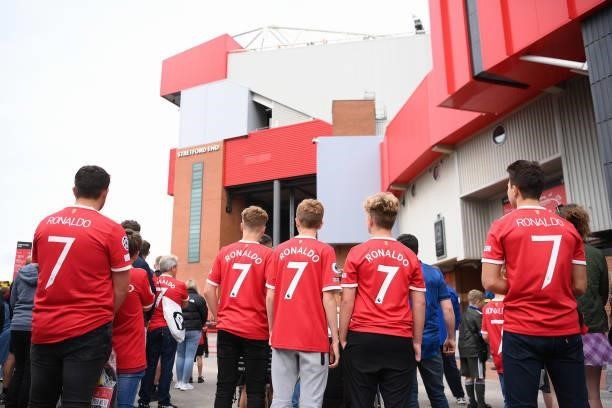 Fans of Manchester United wearing 'Ronaldo - 7' shirts prepare to welcome the players outside the stadium prior to the Premier League match between...