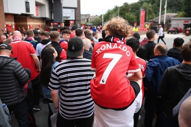 Fans of Manchester United, one wearing a 'Ronaldo - 7' shirt, prepare to welcome the players outside the stadium prior to the Premier League match...