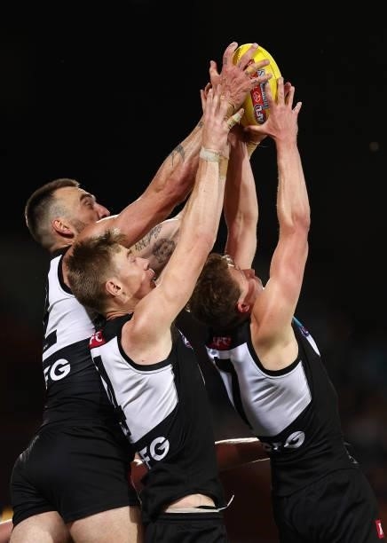 Charlie Dixon, Todd Marshall and Xavier Duursma of the Power all attempt to mark the ball during the AFL Second Preliminary Final match between Port...