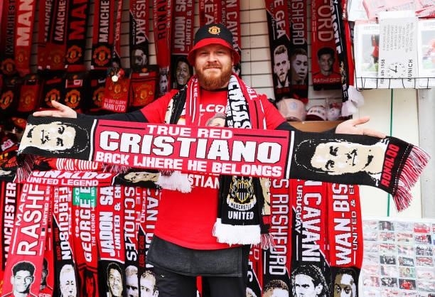 Merchandise seller holds a scarf with the face of Cristiano Ronaldo of Manchester United on outside the stadium prior to the Premier League match...