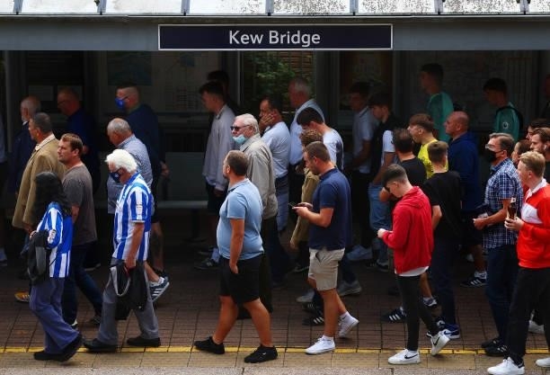 Fans make their way towards the stadium prior to the Premier League match between Brentford and Brighton & Hove Albion at Brentford Community Stadium...