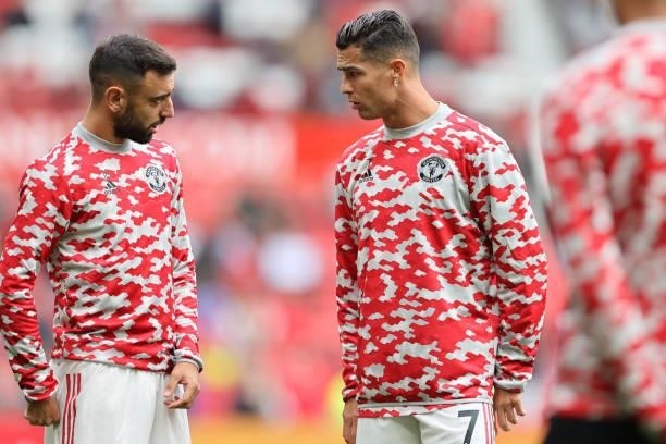 Cristiano Ronaldo and Bruno Fernandes of Manchester United speak as they warm up prior to the Premier League match between Manchester United and...