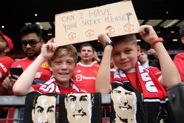 Fans of Manchester United hold aloft a sign asking for the shirt of Cristiano Ronaldo of Manchester United prior to the Premier League match between...