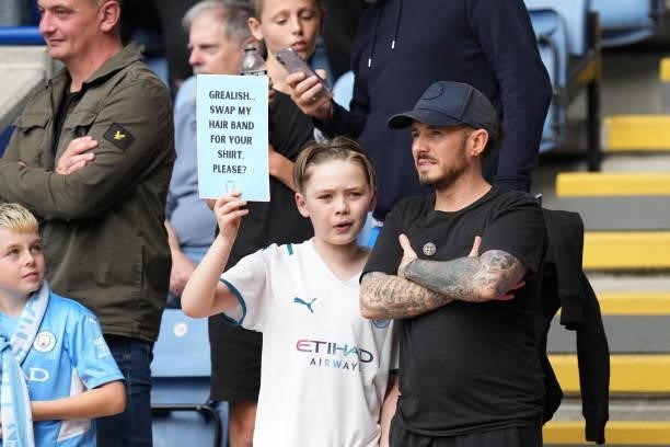 Fan holds aloft a sign asking for the shirt of Jack Grealish of Manchester City during the Premier League match between Leicester City and Manchester...