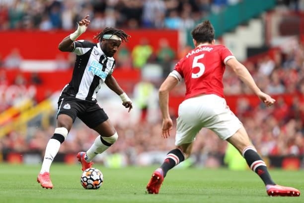 Allan Saint-Maximin of Newcastle United runs with the ball whilst under pressure from Harry Maguire of Manchester United during the Premier League...