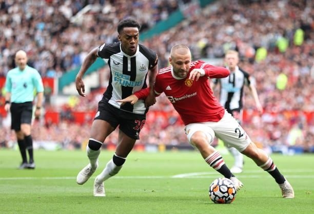 Luke Shaw of Manchester United battles for possession with Joe Willock of Newcastle United during the Premier League match between Manchester United...