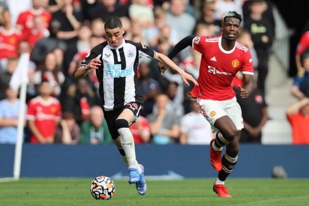 Miguel Almiron of Newcastle United runs with the ball whilst under pressure from Paul Pogba of Manchester United during the Premier League match...