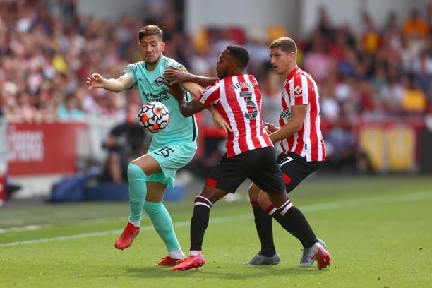 Rico Henry of Brentford battles for possession with Jakub Moder of Brighton & Hove Albion during the Premier League match between Brentford and...