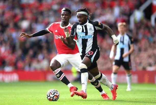 Allan Saint-Maximin of Newcastle United runs with the ball whilst under pressure from Paul Pogba of Manchester United during the Premier League match...