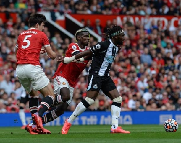 Allan Saint-Maximin of Newcastle United FC controls the ball as Paul Pogba of Manchester United defends during the Premier League match between...