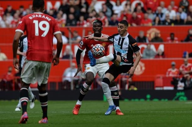 Miguel Almirón of Newcastle United FC controls the ball as Paul Pogba of Manchester United applies pressure during the Premier League match between...