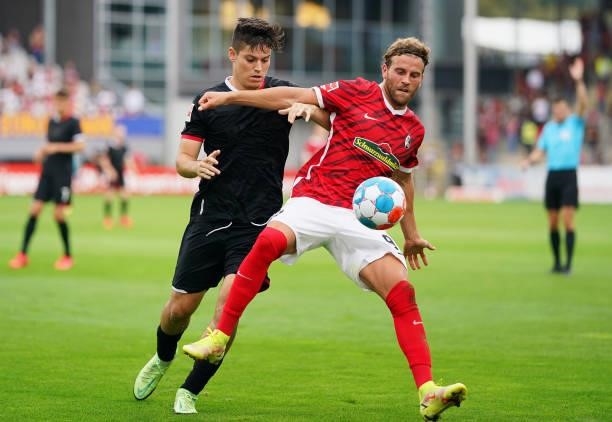 Lucas Hoeler of SC Freiburg battles for possession with Jorge Mere of 1.FC Koeln during the Bundesliga match between Sport-Club Freiburg and 1. FC...