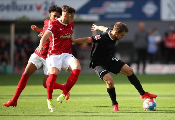 Louis Schaub of 1.FC Koeln battles for possession with Ermedin Demirovic of SC Freiburg during the Bundesliga match between Sport-Club Freiburg and...