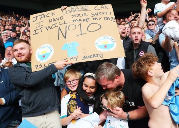 Fans of Manchester City hold aloft a sign asking for the shirt of Jack Grealish of Manchester City during the Premier League match between Leicester...