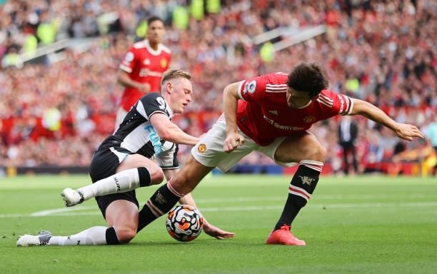 Sean Longstaff of Newcastle United is challenged by Harry Maguire of Manchester United during the Premier League match between Manchester United and...
