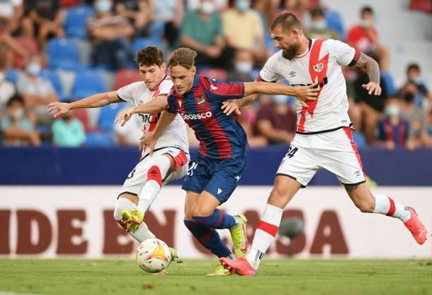 Dani Gomez of Levante battles for possession with Fran Garcia and Esteban Saveljich of Rayo Vallecano during the LaLiga Santander match between...