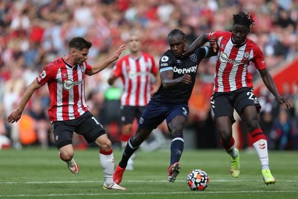 Michail Antonio of West Ham United battles for possession with Jack Stephens and Mohammed Salisu of Southampton during the Premier League match...