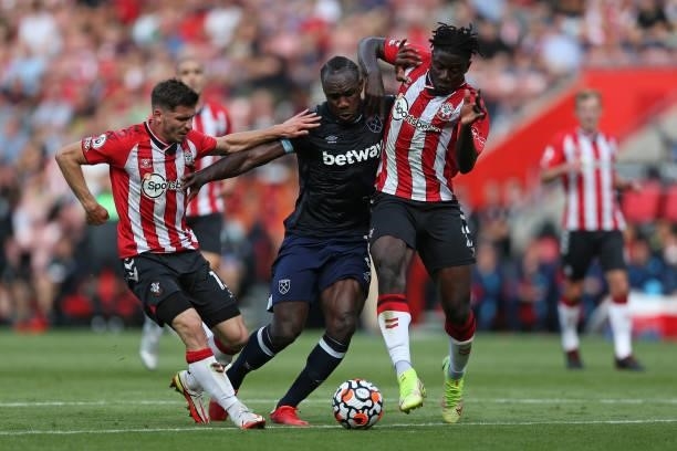 Michail Antonio of West Ham United battles for possession with Jack Stephens and Mohammed Salisu of Southampton during the Premier League match...