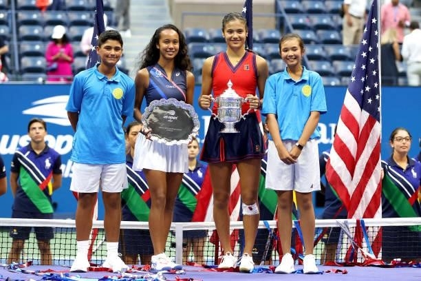 Leylah Annie Fernandez of Canada holds the runner-up trophy as Emma Raducanu of Great Britain celebrates with the championship trophy after their...