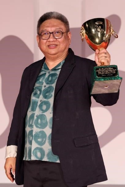 Director Erik Matti poses, on behalf of actor John Arcilla, with the Coppa Volpi for Best Actor for "On the Job: The Missing 8