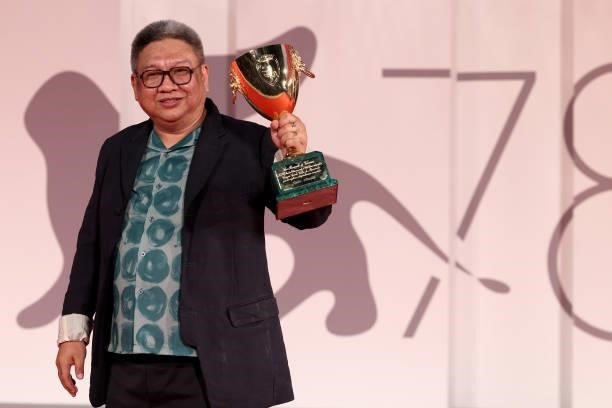 Director Erik Matti poses, on behalf of actor John Arcilla, with the Coppa Volpi for Best Actor for "On the Job: The Missing 8