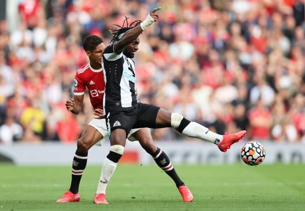 Allan Saint-Maximin of Newcastle United battles for possession with Raphael Varane of Manchester United during the Premier League match between...
