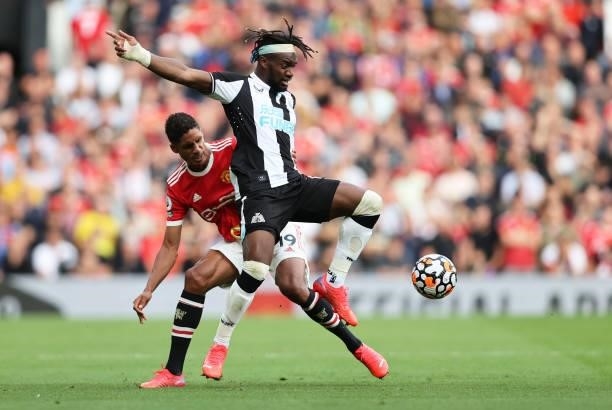 Allan Saint-Maximin of Newcastle United battles for possession with Raphael Varane of Manchester United during the Premier League match between...