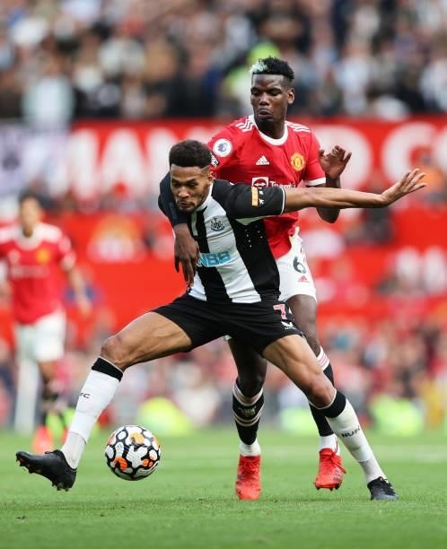 Joelinton of Newcastle United battles for possession with Paul Pogba of Manchester United during the Premier League match between Manchester United...