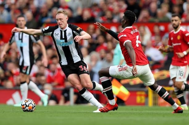 Sean Longstaff of Newcastle United moves away from Paul Pogba of Manchester United during the Premier League match between Manchester United and...