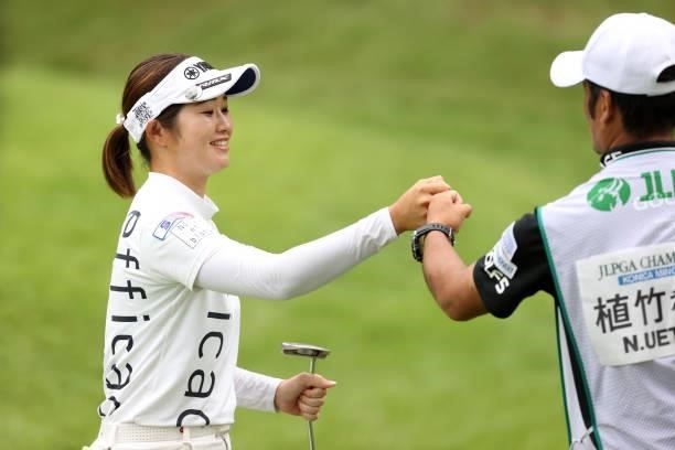 Nozomi Uetake of Japan fist bumps with her caddie after the birdie on the 6th green during the final round of the JLPGA Championship Konica Minolta...