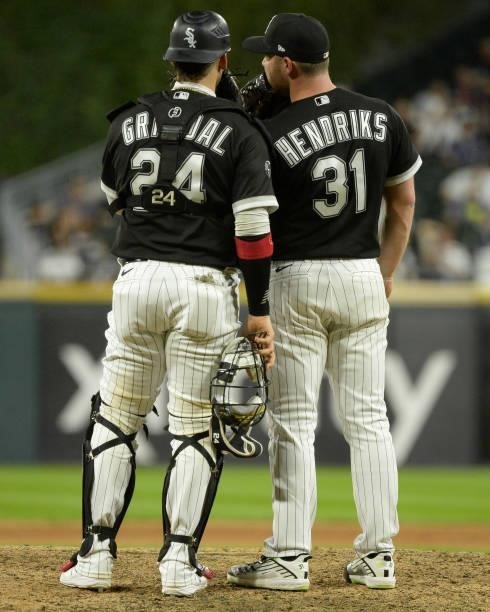 Yasmani Grandal and Liam Hendriks of the Chicago White Sox meet at the pitchers mound during the game against the Boston Red Sox on September 10,...