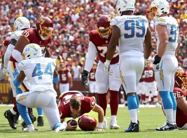 Ryan Fitzpatrick of the Washington Football Team has his helmet knocked off against the Los Angeles Chargers during the first half at FedExField on...