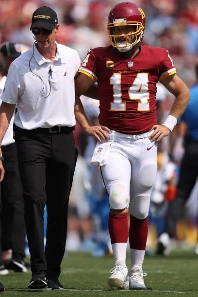 Ryan Fitzpatrick of the Washington Football Team is checked on by trainers after being hit and injured against the Los Angeles Chargers during the...