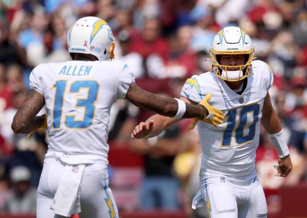 Justin Herbert and Keenan Allen celebrate against the Washington Football Team during the first half at FedExField on September 12, 2021 in Landover,...