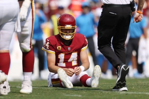 Ryan Fitzpatrick of the Washington Football Team is checked on by trainers after being hit and injured against the Los Angeles Chargers during the...