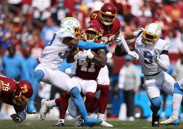 McKissic of the Washington Football Team is tackled by Derwin James of the Los Angeles Chargers at FedExField on September 12, 2021 in Landover,...