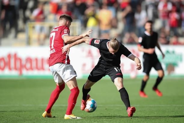 Lukas Kuebler of SC Freiburg is tackled by Florian Kainz of 1.FC Koeln during the Bundesliga match between Sport-Club Freiburg and 1. FC Köln at...