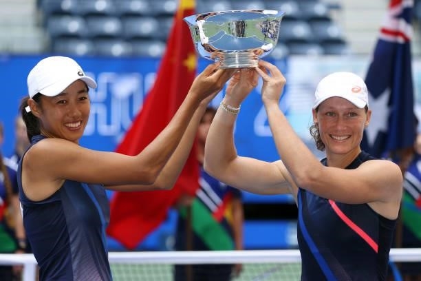 Shuai Zhang of China and Samantha Stosur of Australia celebrate with the championship trophy after defeating Coco Gauff of the United States and...