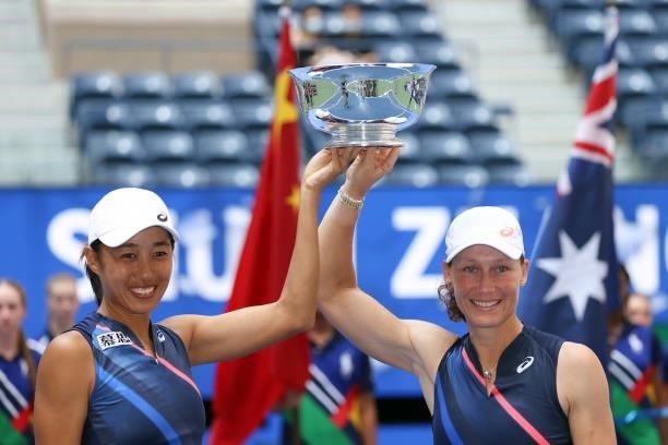 Shuai Zhang of China and Samantha Stosur of Australia celebrate with the championship trophy after defeating Coco Gauff of the United States and...
