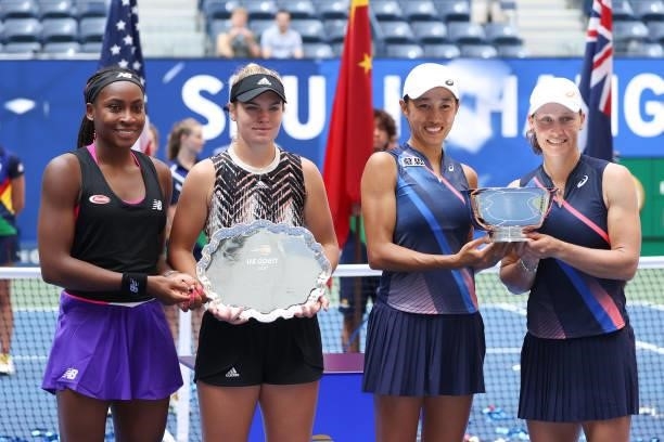 Coco Gauff of the United States and Catherine McNally of the United States smile with the runner-up trophy alongside Shuai Zhang of China and...