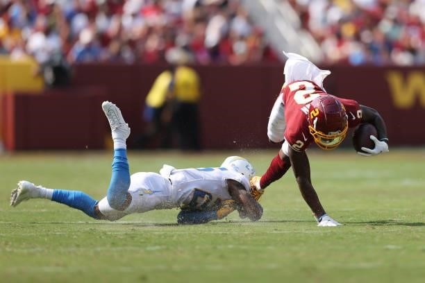 Dyami Brown of the Washington Football Team is tackled by Chris Harris of the Los Angeles Chargers during the third quarter at FedExField on...