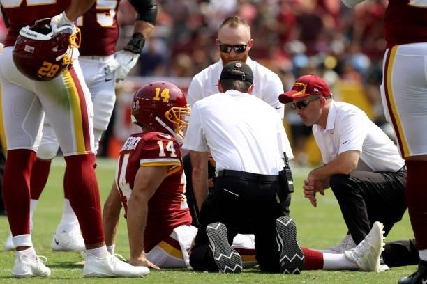 Ryan Fitzpatrick of the Washington Football Team is looked at by team doctors after being injured against the Los Angeles Chargers during the first...