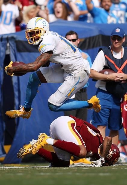 Keenan Allen of the Los Angeles Chargers jumps over Torry McTyer of the Washington Football Team during the third quarter at FedExField on September...