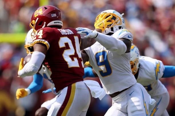 Antonio Gibson of the Washington Football Team stiff arms Kenneth Murray of the Los Angeles Chargers during the second half at FedExField on...