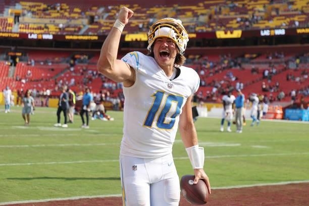 Justin Herbert of the Los Angeles Chargers celebrates after defeating the Washington Football Team 20-16 at FedExField on September 12, 2021 in...