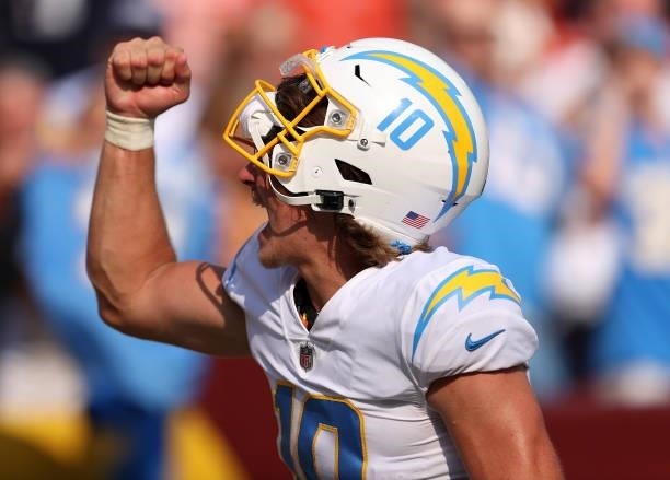 Justin Herbert of the Los Angeles Chargers celebrates after defeating the Washington Football Team 20-16 at FedExField on September 12, 2021 in...