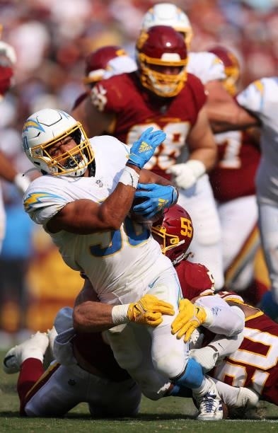 Austin Ekeler of the Los Angeles Chargers is tackled against the Washington Football Team at FedExField on September 12, 2021 in Landover, Maryland.