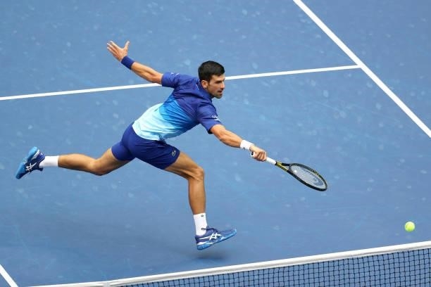 Novak Djokovic of Serbia reaches to return the ball against Daniil Medvedev of Russia during their Men's Singles final match on Day Fourteen of the...