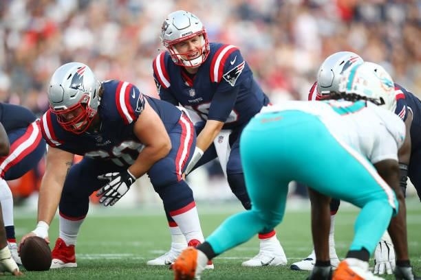 Mac Jones of the New England Patriots looks on from under center against the Miami Dolphins during the first half at Gillette Stadium on September...