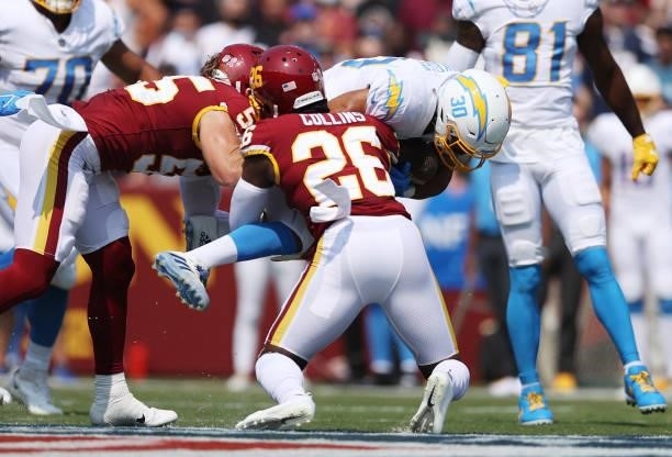 Austin Ekeler of the Los Angeles Chargers is hit by Landon Collins of the Washington Football Team during the first quarter at FedExField on...